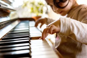 cute little girl playing on old piano